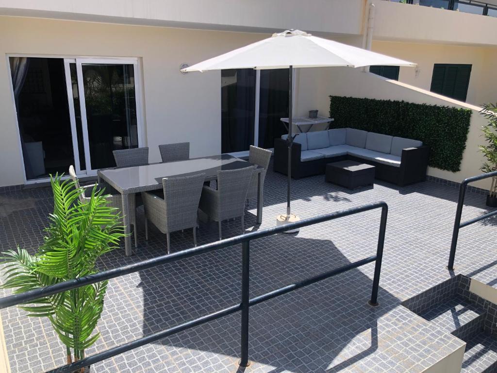 a patio with a table and chairs and an umbrella at Ocean Dream Apartment in Funchal