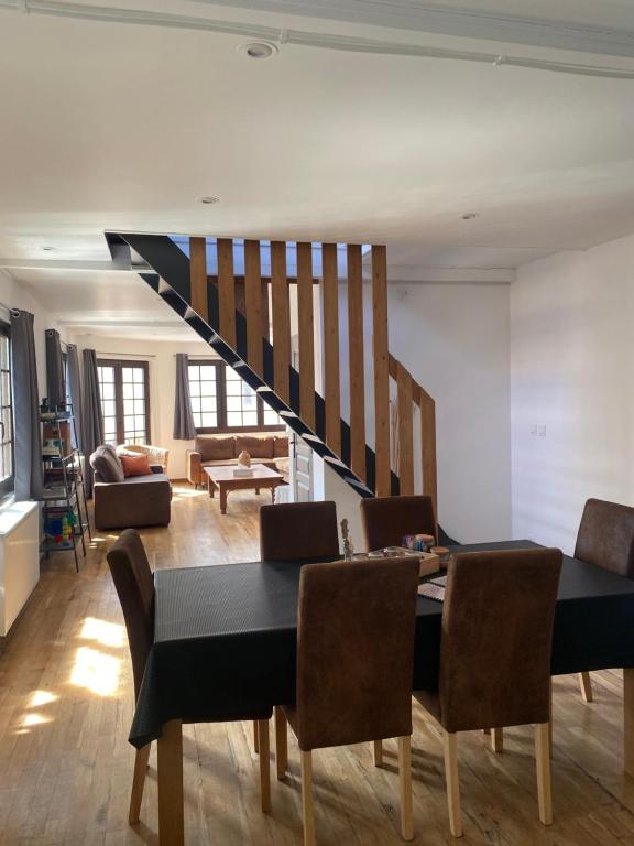 a dining room with a table and chairs and a staircase at Superbe appartement F4 au cœur de Malo-les-bains in Dunkerque