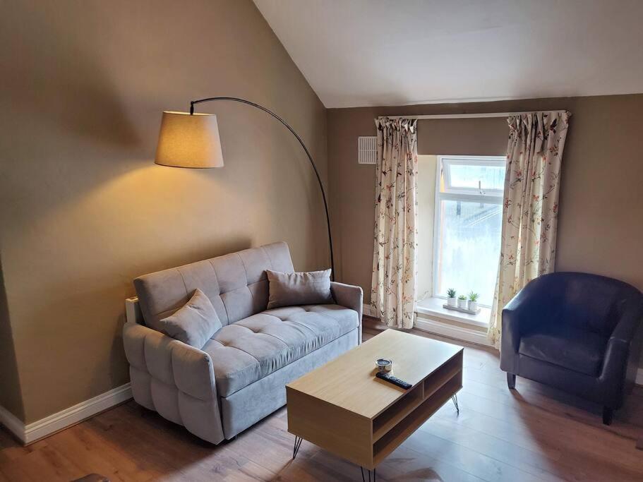 uma sala de estar com um sofá e uma mesa em Apt. 2 - Town Centre Apartment em Bagenalstown