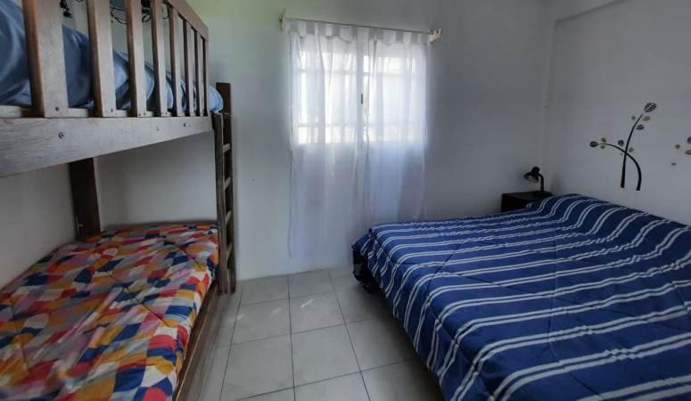 1 dormitorio con 1 cama y 1 litera en Departamentos Vistalmar San Patricio en Mar del Plata