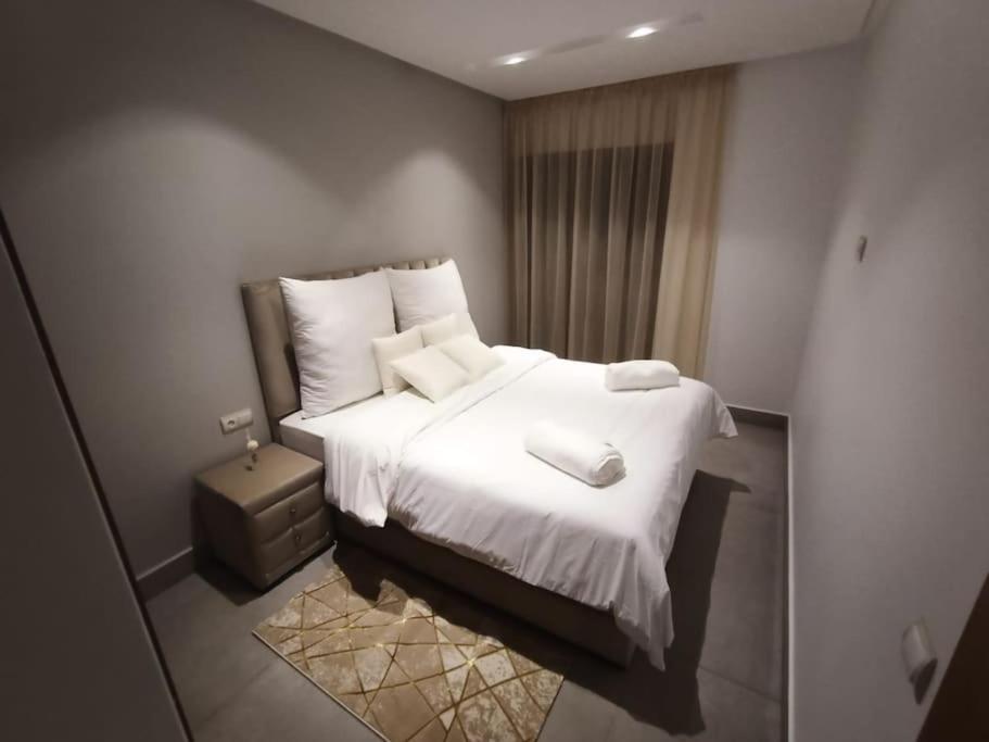 um quarto com uma cama com lençóis brancos e almofadas em luxury studio in Casablanca em Casablanca