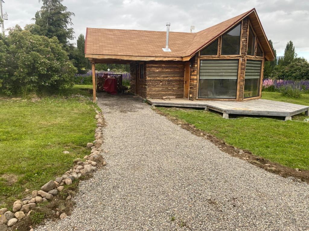 a log cabin with a gravel path in front of it at Cabañas 2 Hermanos in Coihaique