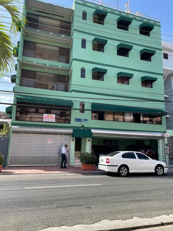 un coche blanco estacionado frente a un edificio en Torres Apart Studio, en Santo Domingo