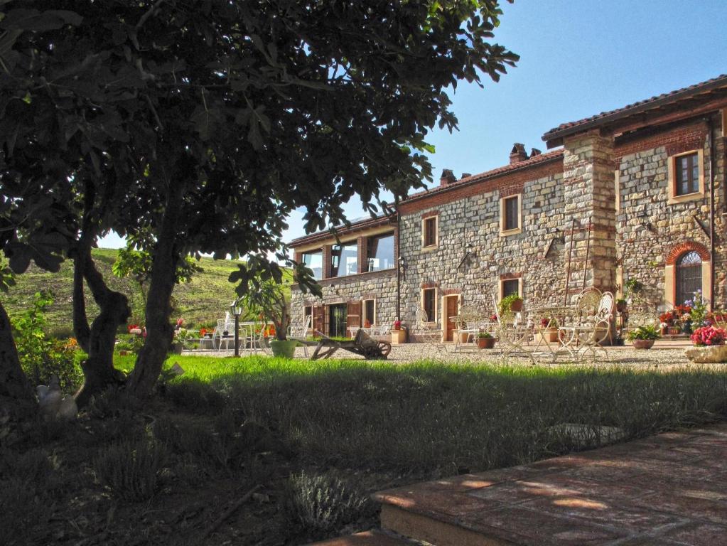 una casa de piedra con un árbol delante en Tenuta il Galletto, en Casale Monferrato