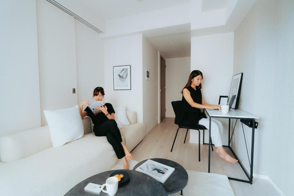 Dos mujeres sentadas en un sofá en una sala de estar en n'estate Kagurazaka, en Tokio