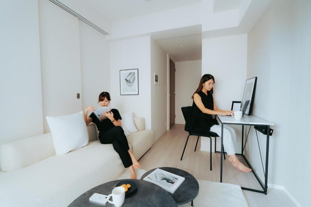 two women sitting on a couch in a living room at n'estate 神楽坂 in Tokyo