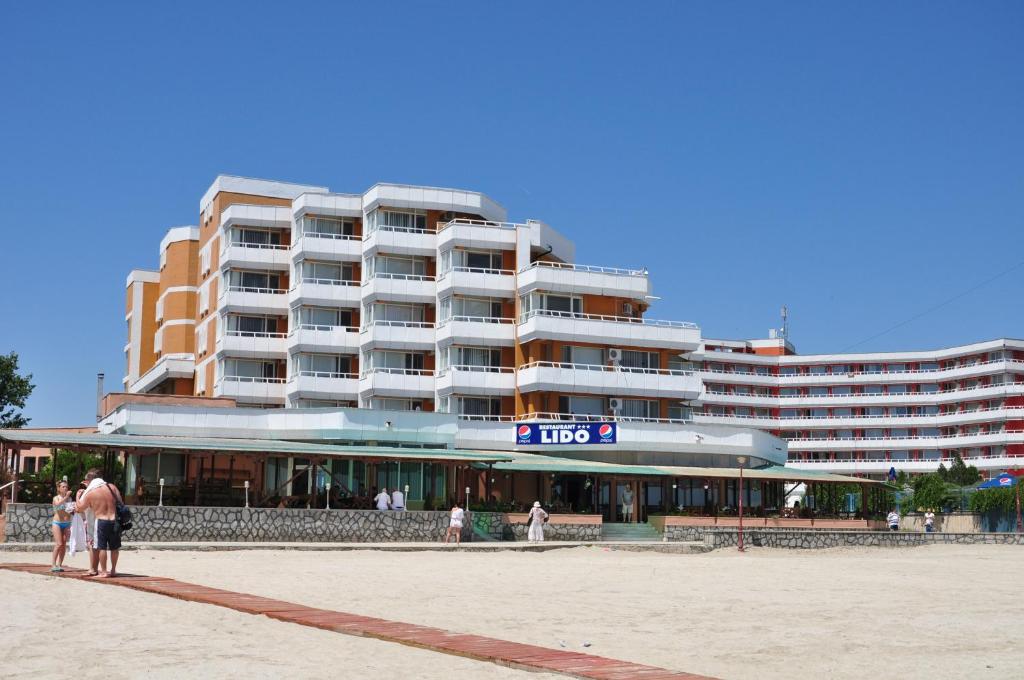 a large building with people standing in front of it at Hotel Lido in Mamaia