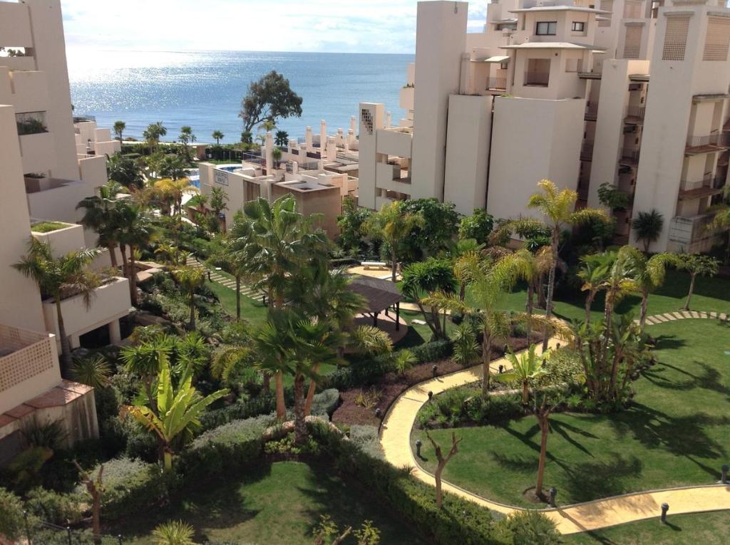 una vista aérea de un complejo con palmeras y el océano en WaterFront Apartment, en Estepona