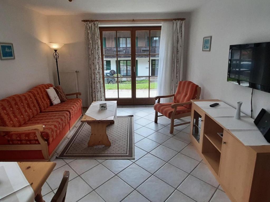 uma sala de estar com um sofá e uma televisão em Schönbrunn holiday home in Bayrischzell em Bayrischzell