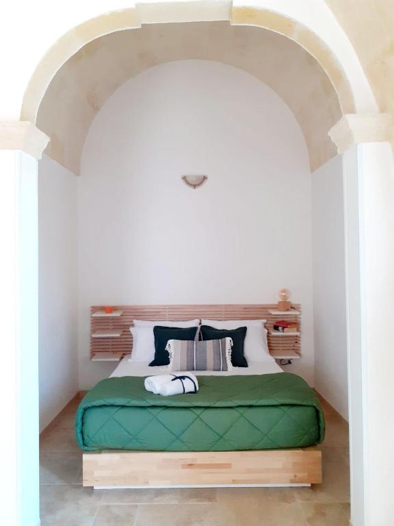 - une chambre blanche avec un lit vert dans l'établissement Casa Borromeo, à Villa Castelli