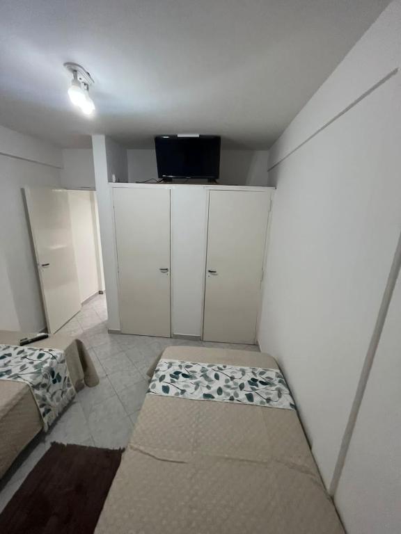 um quarto com armários brancos e uma cama nele em Jz em Resistência