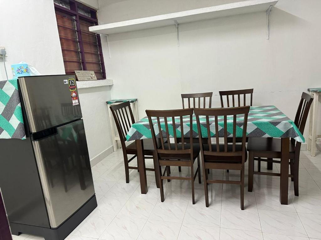 a dining room with a table and chairs and a refrigerator at Stay Padang Rengas in Padang Rengas