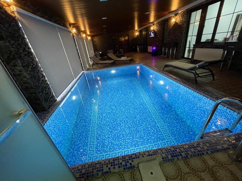 a large blue swimming pool in a building at Premium VILLA (LUXURY Mansion) in Şamaxı