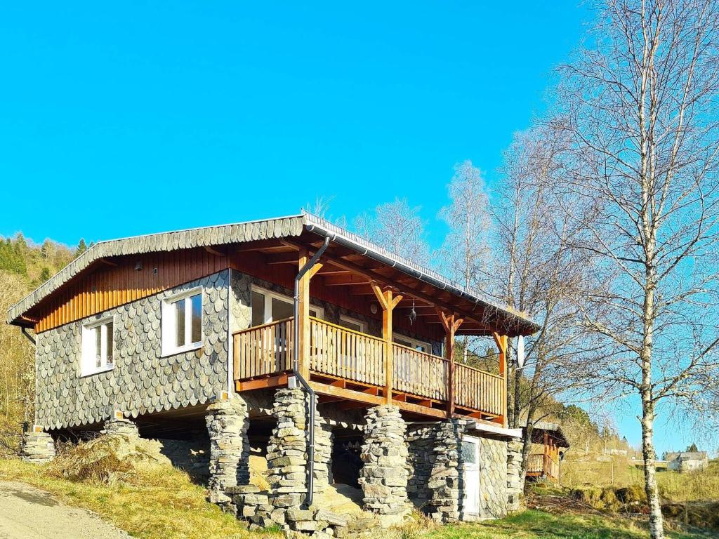una casa de madera con balcón en la parte superior. en Holiday home LONEVÅG, en Lonevåg