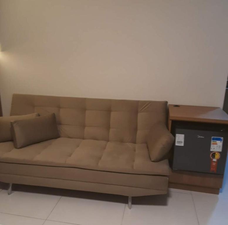 a brown couch sitting in a room with a desk at Pousada Bienenwabe Suítes in São Pedro de Alcântara