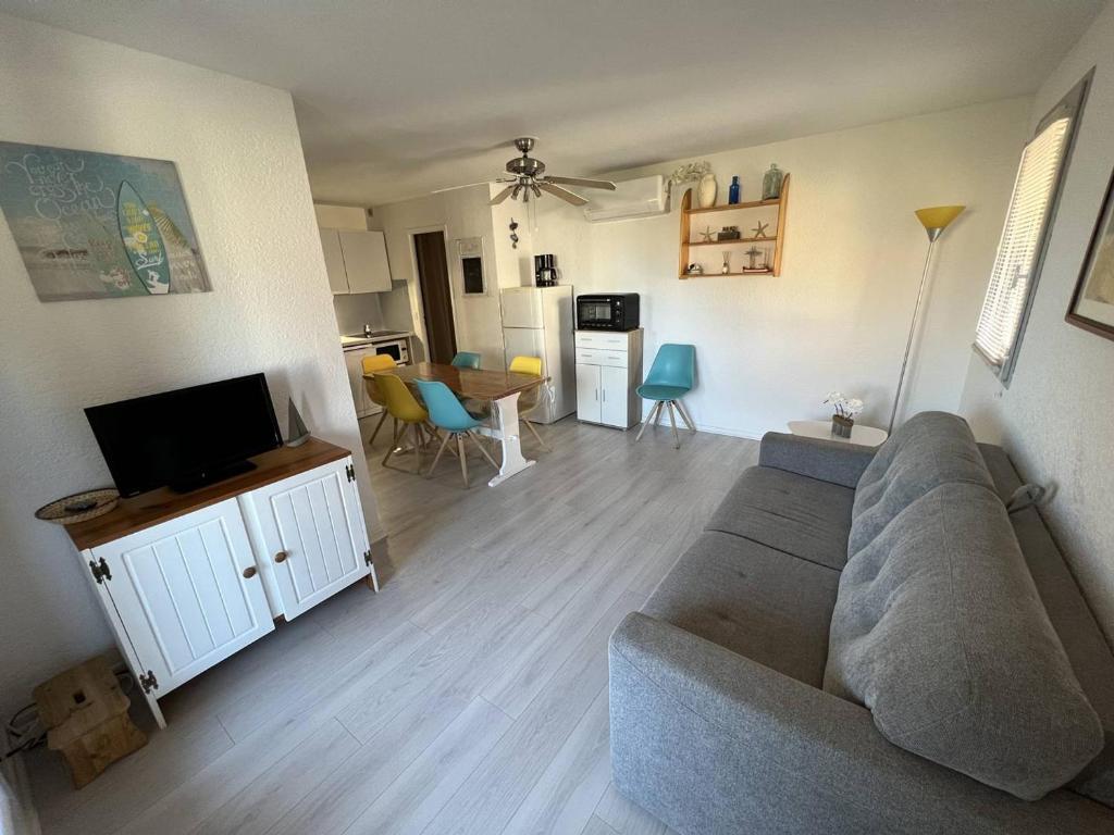 un salon avec un canapé et une télévision dans l'établissement Appartement T2 climatisé, rénové, proche plage, avec terrasse et parking - Port Leucate - FR-1-81-586, à Port-Leucate