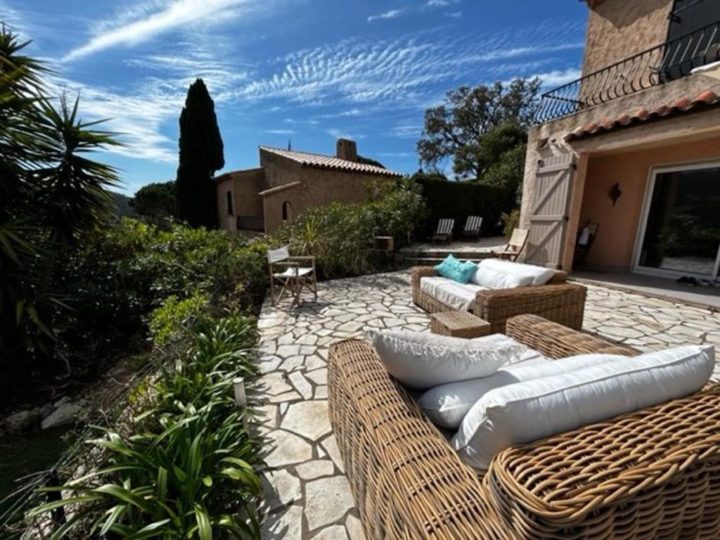 un patio avec des meubles en osier sur un patio en pierre dans l'établissement Appartement Rénové avec Jardin à 1.2km de la Plage de Gigaro, La Croix-Valmer - FR-1-726-23, à La Croix-Valmer