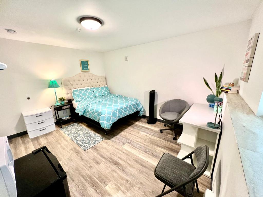 a bedroom with a bed and a desk and chairs at Studio Apartment with Shared Bathroom 10 minutes walk to University of WA in Seattle