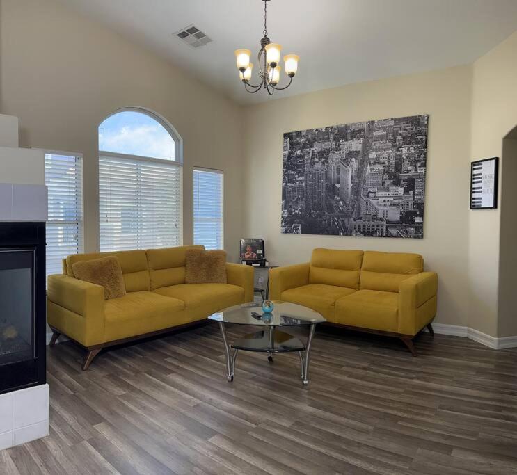 a living room with two yellow couches and a table at Gorgeous home away from home in Las Vegas