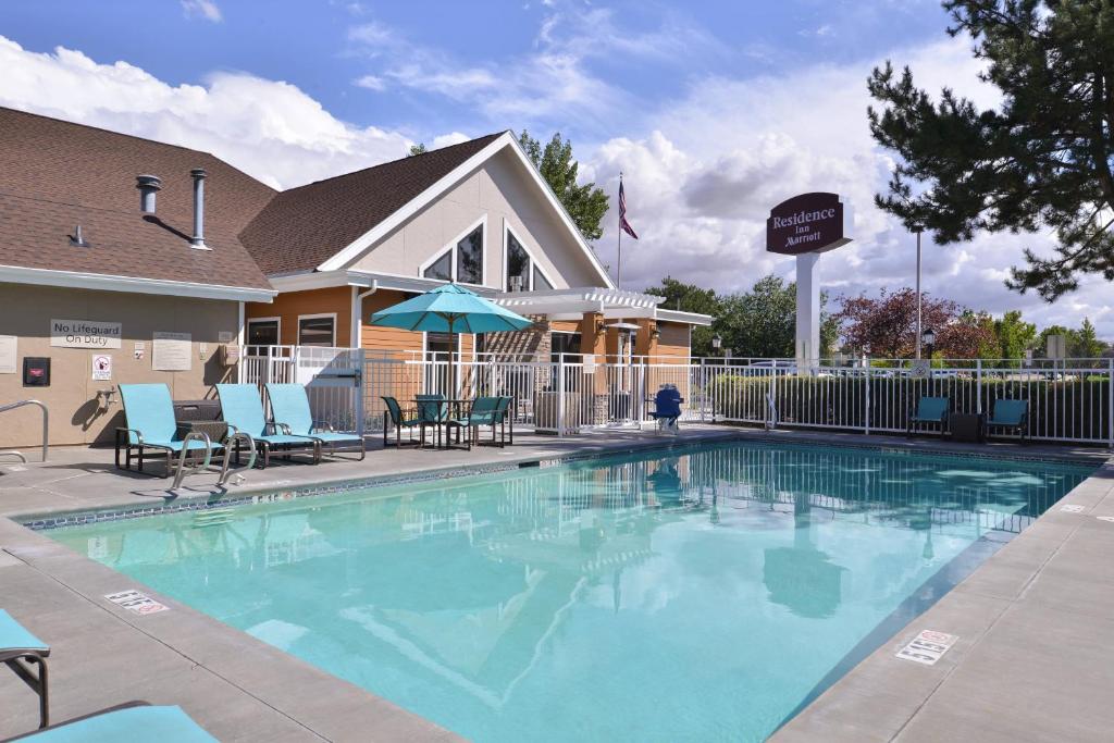 a large swimming pool with chairs and umbrellas next to a building at Residence Inn by Marriott Boise Downtown/University in Boise