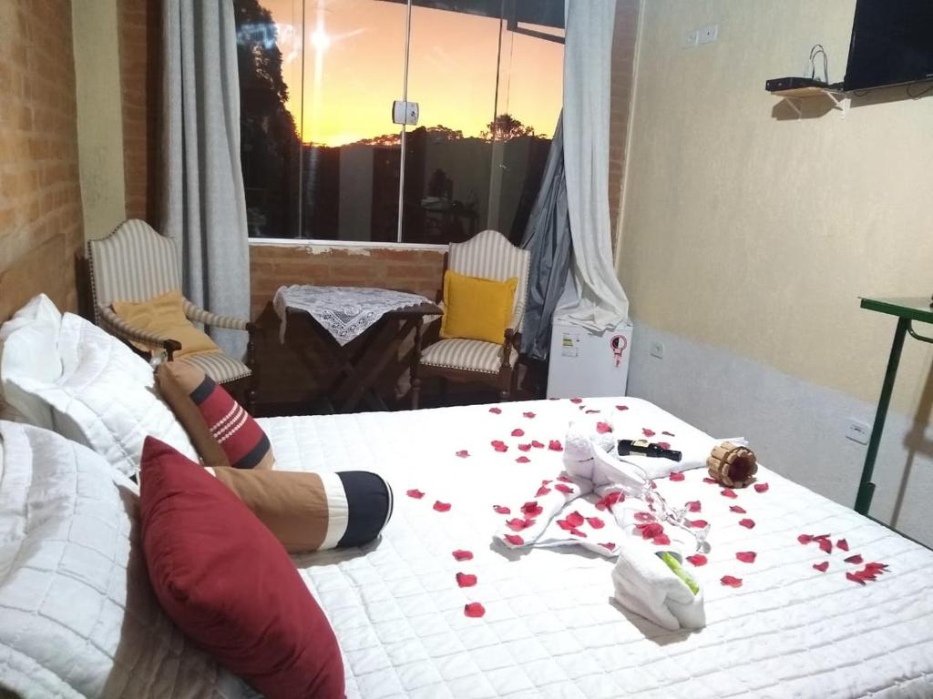 a bedroom with a bed with red pills on it at All Green Residence in Monte Verde
