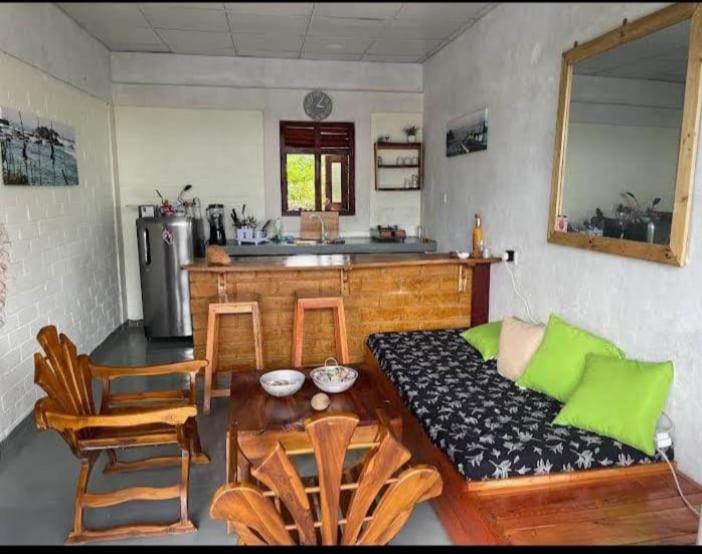 a living room with a couch and a kitchen at Gray house up in Weligama