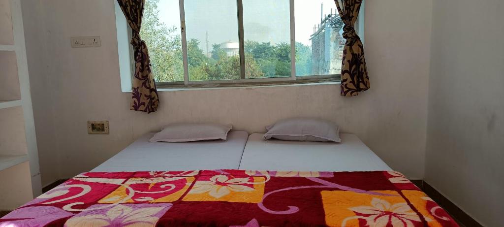 Una cama sentada en una habitación con ventana. en MONIKA MANSION Bodhgaya, en Bodh Gaya