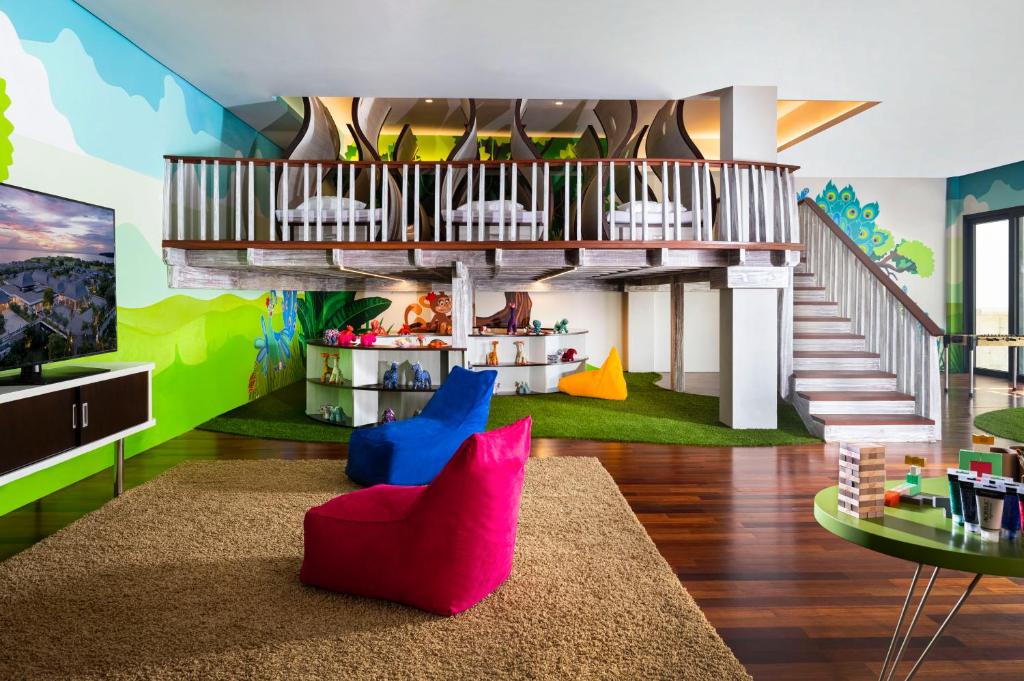 a living room with a staircase and colorful walls at Jumeirah Bali in Uluwatu