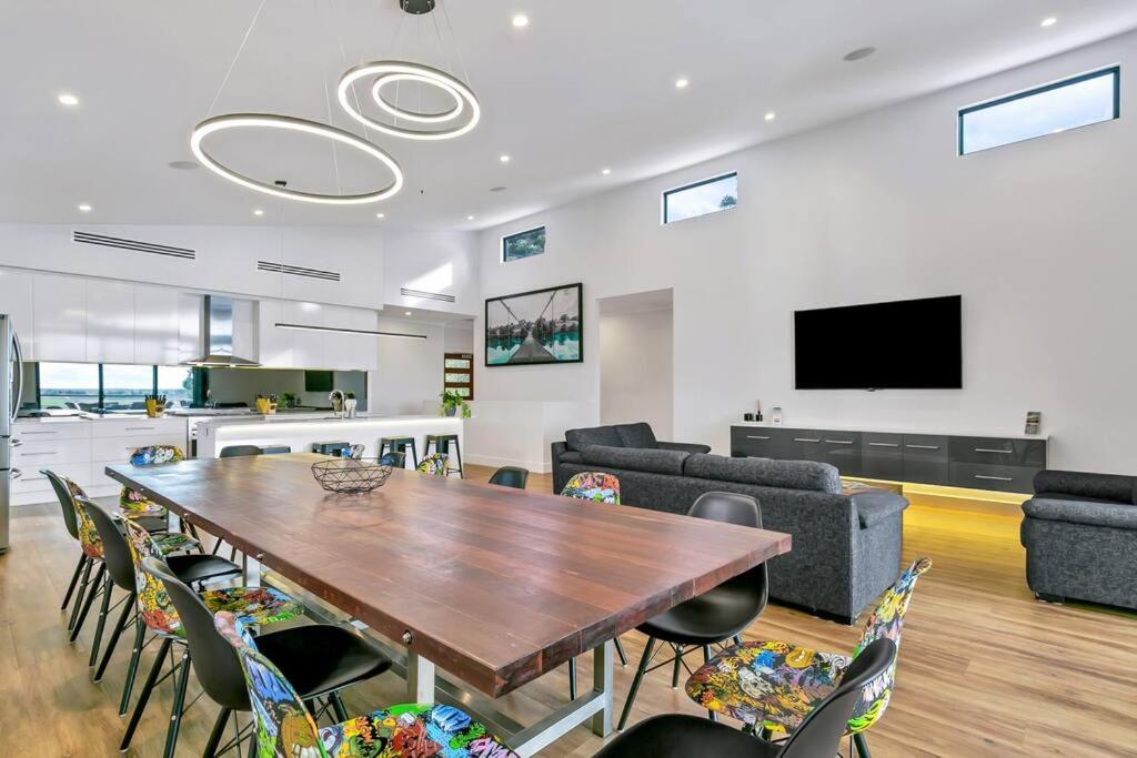 Platinum on Washpool في Wellington East: غرفة معيشة مع طاولة وكراسي خشبية