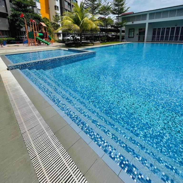 a large swimming pool with blue water in a building at Wallaway2stay Kiara Nilai Apartment 3 Bedroom in Nilai