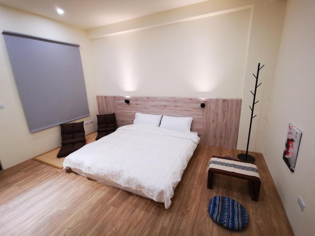 1 dormitorio con cama blanca y pantalla de proyección en 小短腿的家-無人化民宿, en Taitung
