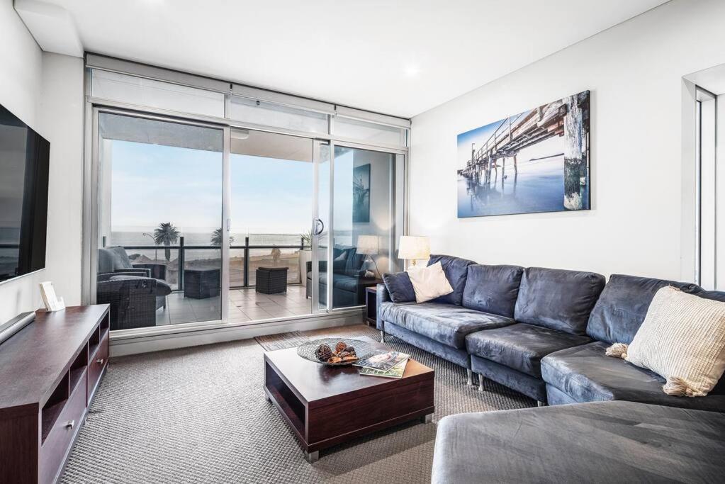 a living room with a couch and a large window at Penthouse 406 The Frontage Victor Harbor in Victor Harbor
