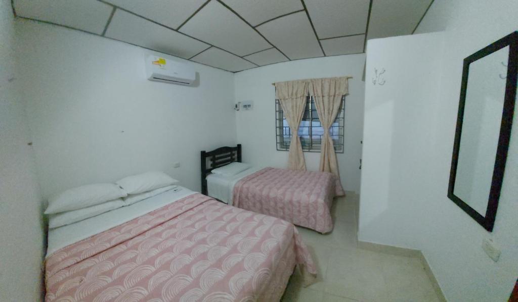 a bedroom with two beds with pink comforter at Guio Apartamentos in San Antero
