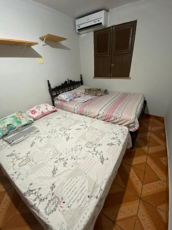 2 Betten nebeneinander in einem Zimmer in der Unterkunft Quarto com ótimo custo benefício in Parnaíba