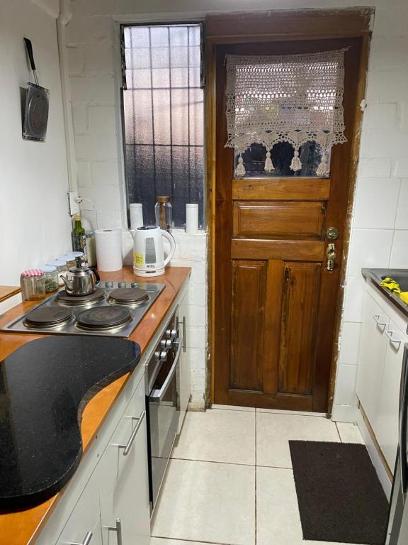 uma cozinha com um lavatório e uma porta de madeira em Casa de Campo em Santa Cruz
