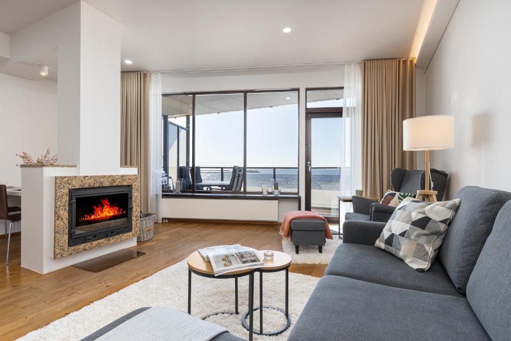 a living room with a couch and a fireplace at BlydeHomes - Amazing Seaview! in Tallinn