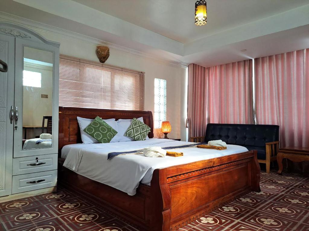 um quarto com uma cama grande e um espelho em Nary Apartment em Siem Reap