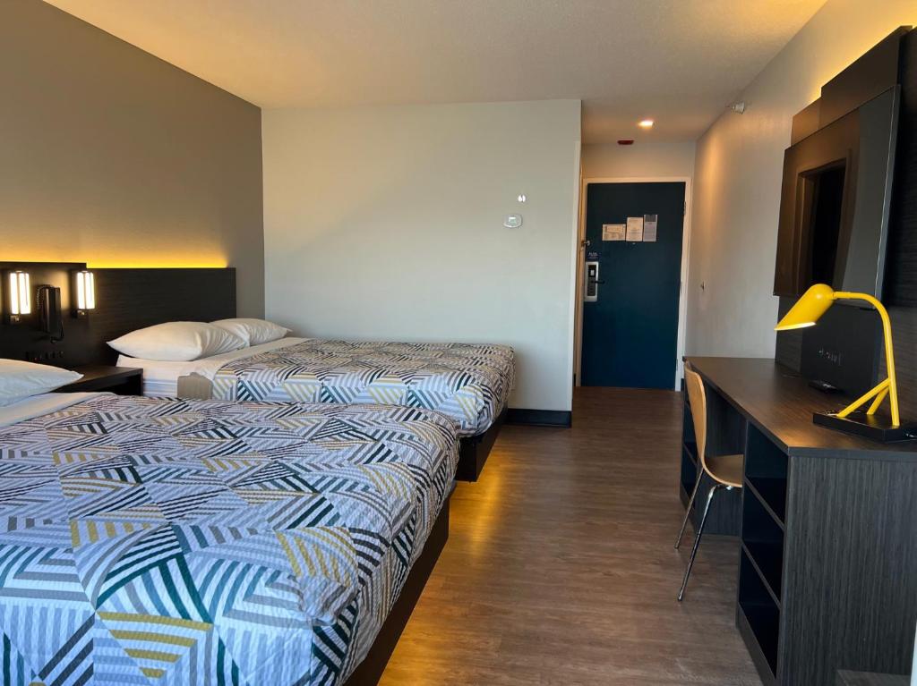 Habitación de hotel con 2 camas y escritorio en Motel 6 Indianapolis North en Indianápolis