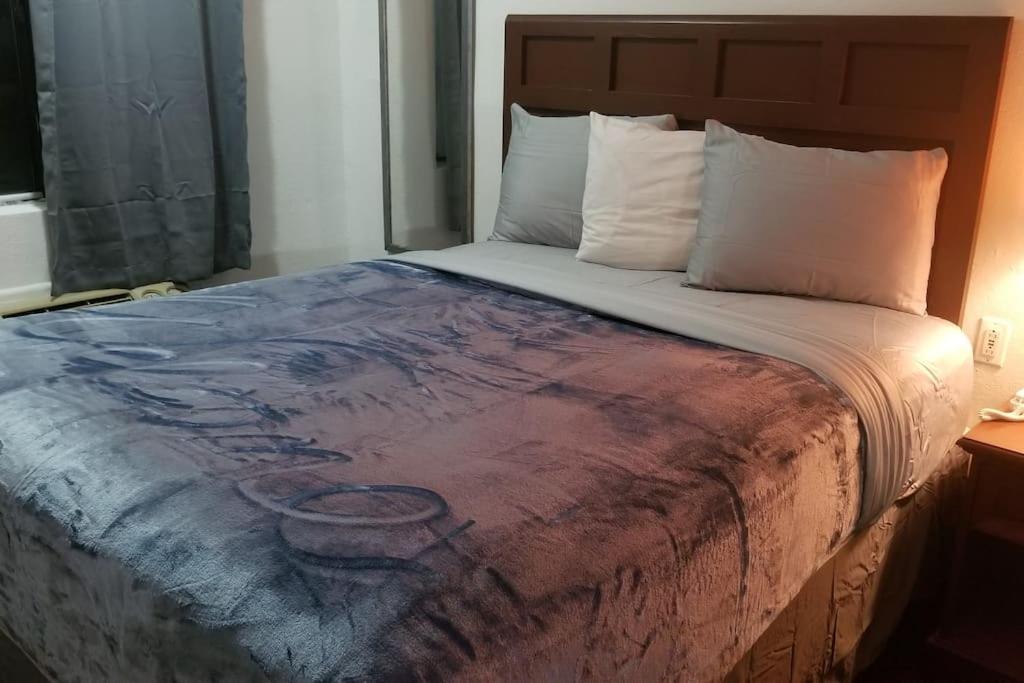 ein Schlafzimmer mit einem Bett mit einem Gemälde darauf in der Unterkunft OSU 2 Queen Beds Hotel Room 230 Wi-Fi Hot Tub Booking in Stillwater
