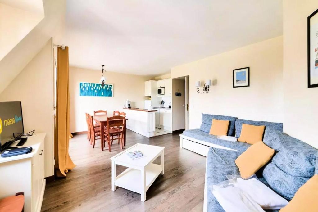 ein Wohnzimmer mit einem Sofa und einem Tisch in der Unterkunft La Résidence du Golf - maeva Home - Appartement 2 Pièces 7 Personnes - Pre 654 in Deauville
