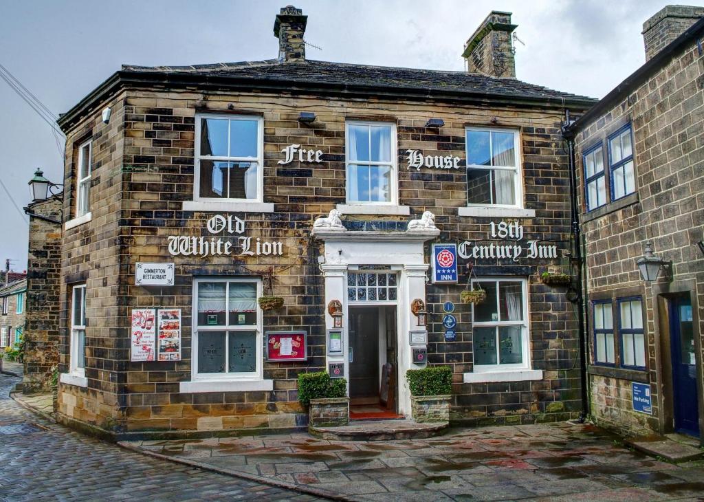 an old brick building on the corner of a street at The Old White Lion Hotel in Haworth