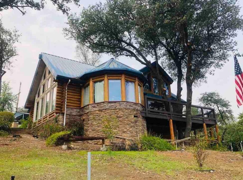 uma casa com uma bandeira ao lado dela em Happy Bear Lodge - Luxury 4 BR Cabin em Shasta Lake