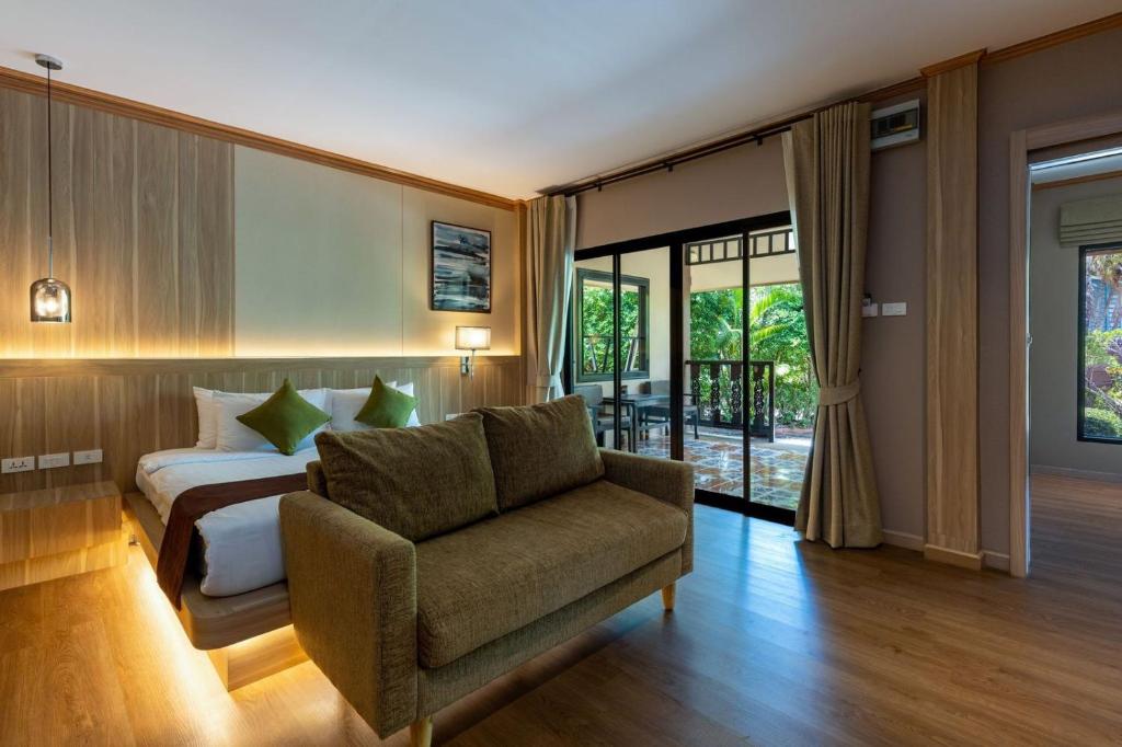 ein Schlafzimmer mit einem Bett, einer Couch und einem Sessel in der Unterkunft Maleedee Bay Resort in Ao Nang Beach