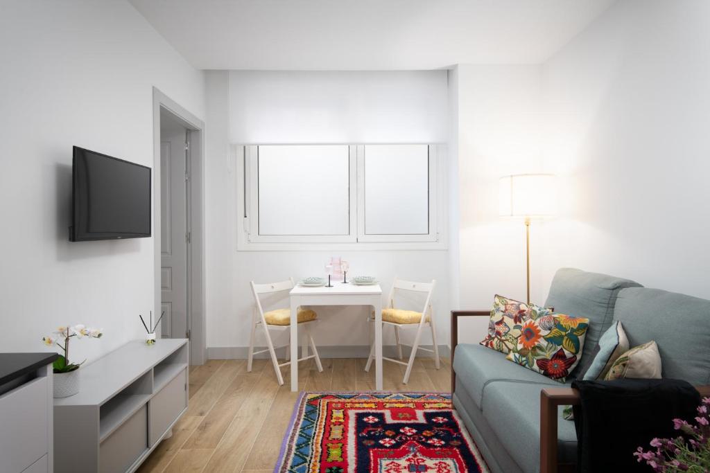 a living room with a couch and a table at Apartamentos La Gringa Centro Gijon II Nueva construcción con posibilidad de Parking in Gijón