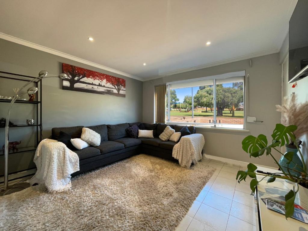 a living room with a couch and a window at Blackwood Stays in Spearwood