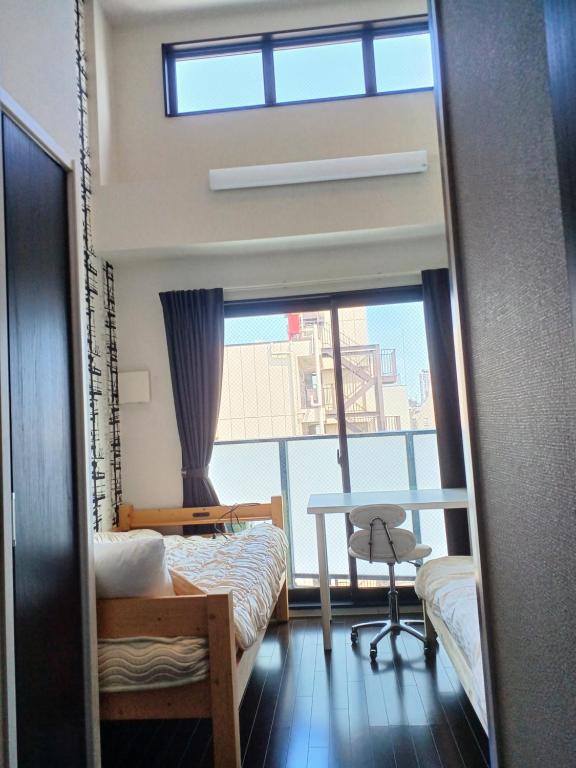大阪市にあるオリエントシティ南堀江ⅡLのベッド2台、テーブル、窓が備わる客室です。