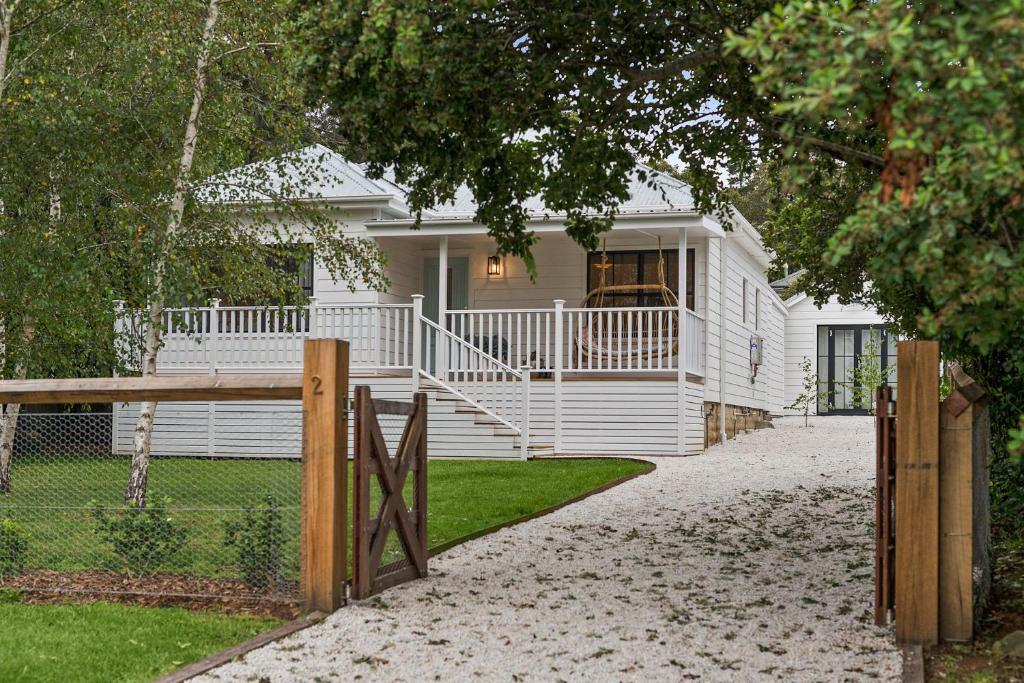 une maison blanche avec une clôture devant elle dans l'établissement Bryony Cottage Berrima, à Berrima