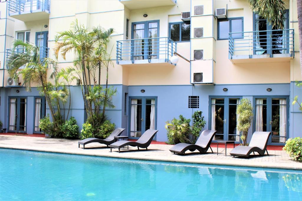 una piscina con sedie a sdraio e un edificio di Technopark Hotel a Santa Rosa