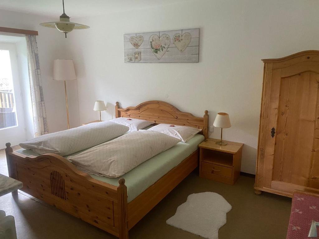 1 dormitorio con cama de madera y puerta de madera en Zimmer 1 am Manötscherhof, en Tires