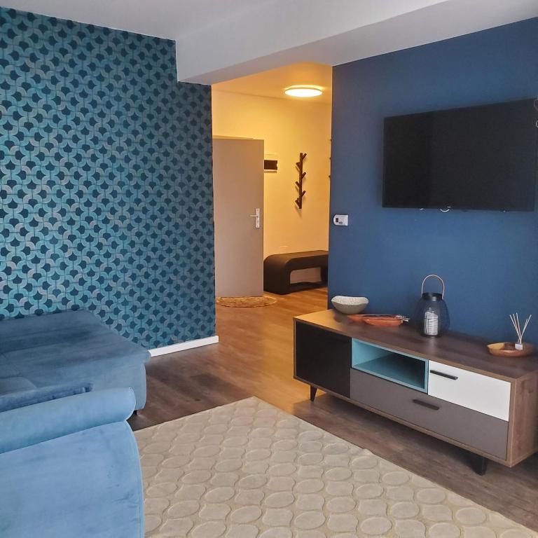 ein Wohnzimmer mit einem Fernseher an einer blauen Wand in der Unterkunft Commodores Quarters in Braşov